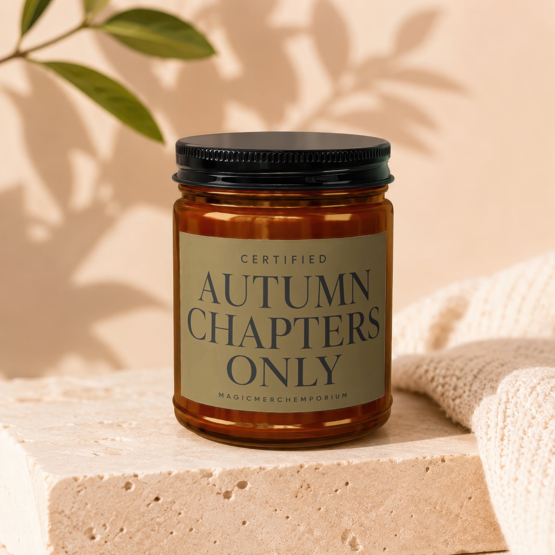 Amber candle with black lid labeled "Certified Autumn Chapters Only".