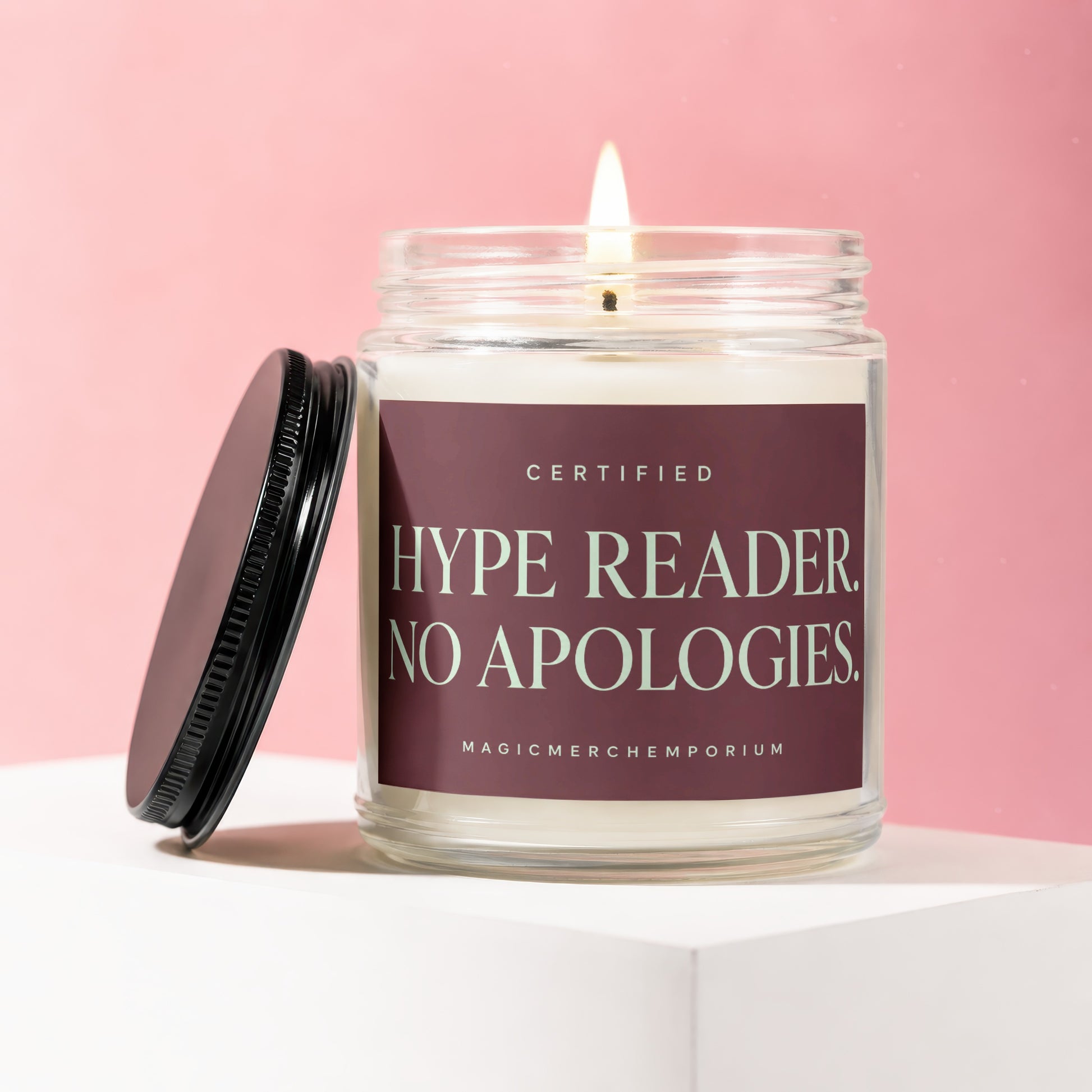 Glass candle with lit wick and black lid; label reads "Certified Hype Reader. No Apologies."