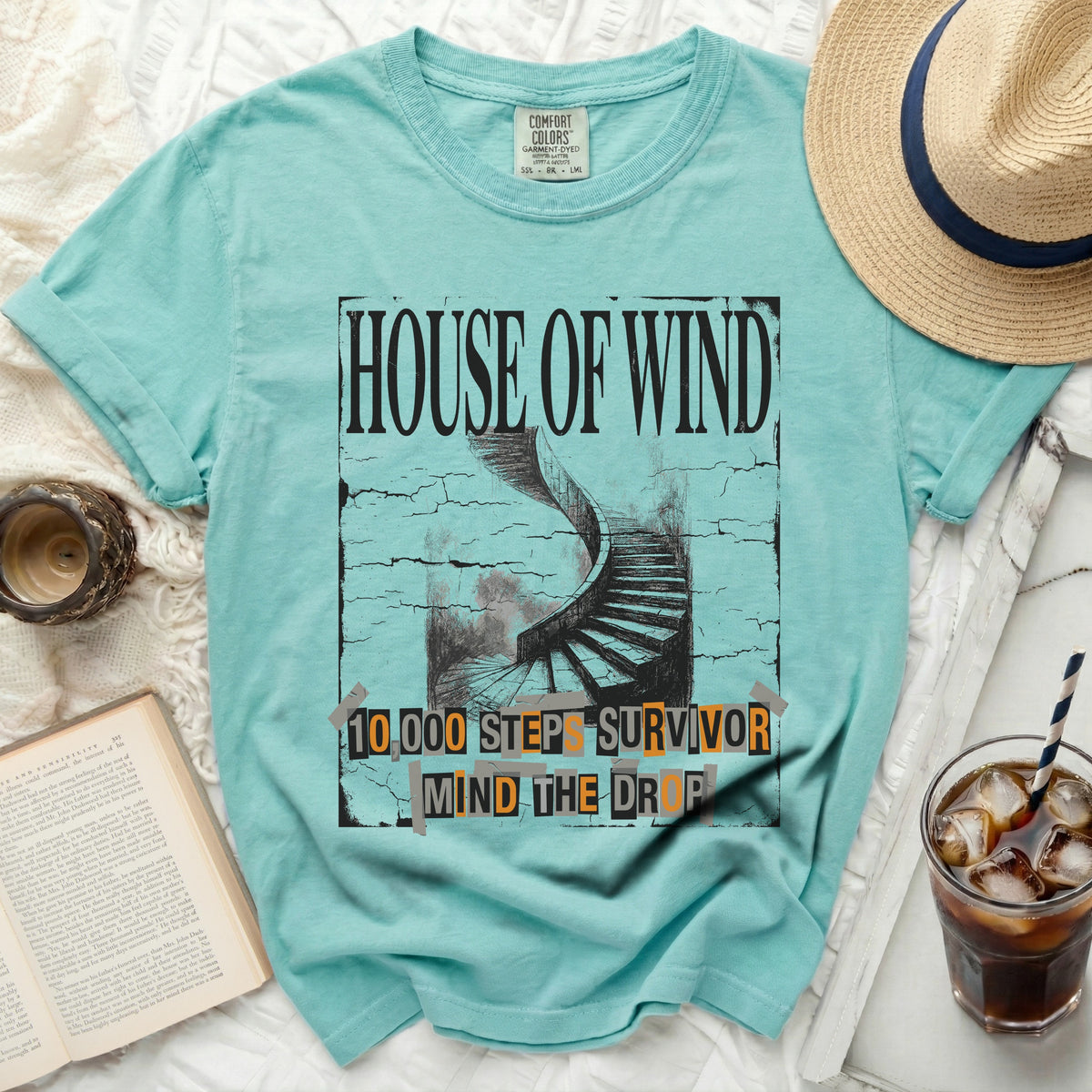 Teal shirt with "House of Wind" and a spiral staircase graphic.