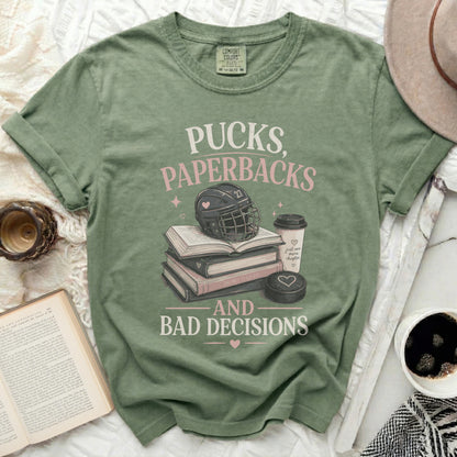 Green t-shirt with text "Pucks, Paperbacks, and Bad Decisions" above hockey gear.