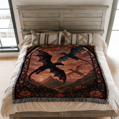 a bed with a large, colorful dragon-themed blanket on it. The blanket has a detailed design depicting two dragons, one black and one blue, against a backdrop of mountains and a sunset.
