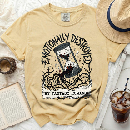 Yellow t-shirt with a graphic of a broken hourglass and thorns, text reads "Emotionally Destroyed by Fantasy Romance".