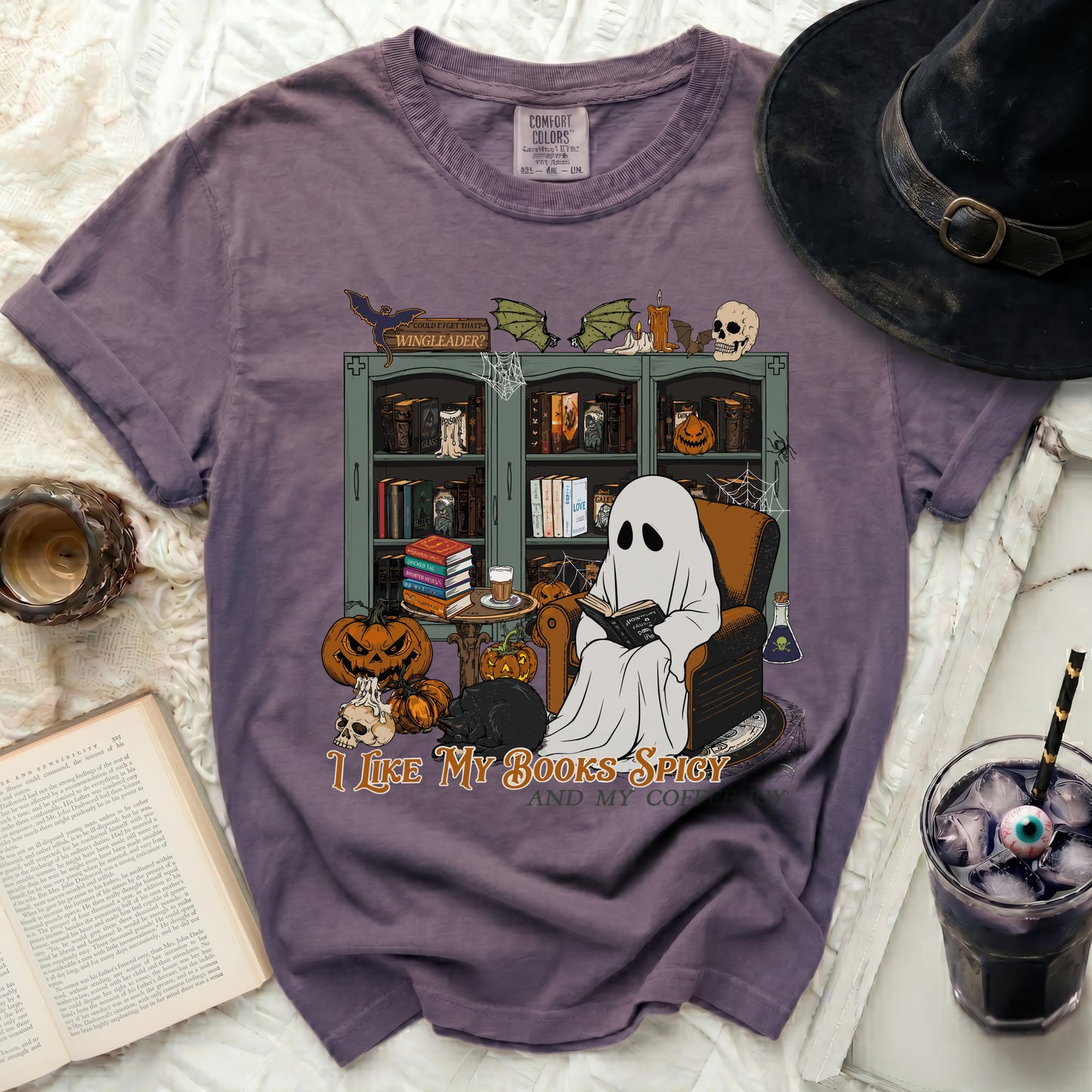 Ghost reading a book with pumpkins and a black cat, "I like my books spicy and my coffee."