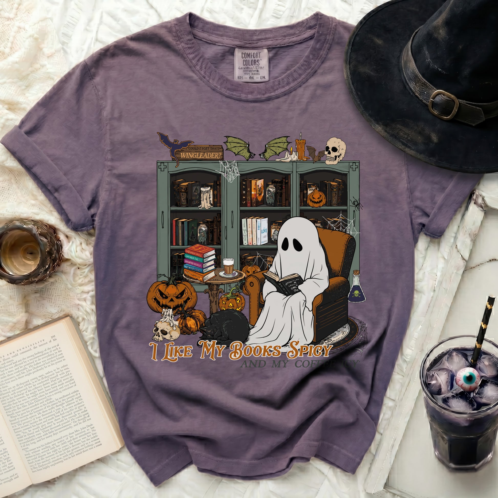 Ghost reading a book with pumpkins and a black cat, "I like my books spicy and my coffee."