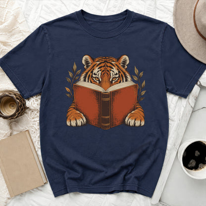 Tiger reading a book with leaves on a navy t-shirt.