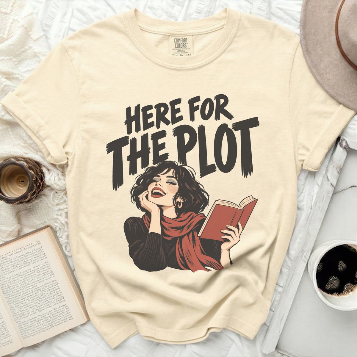 Cream t-shirt with "Here for the Plot" graphic of a woman reading.