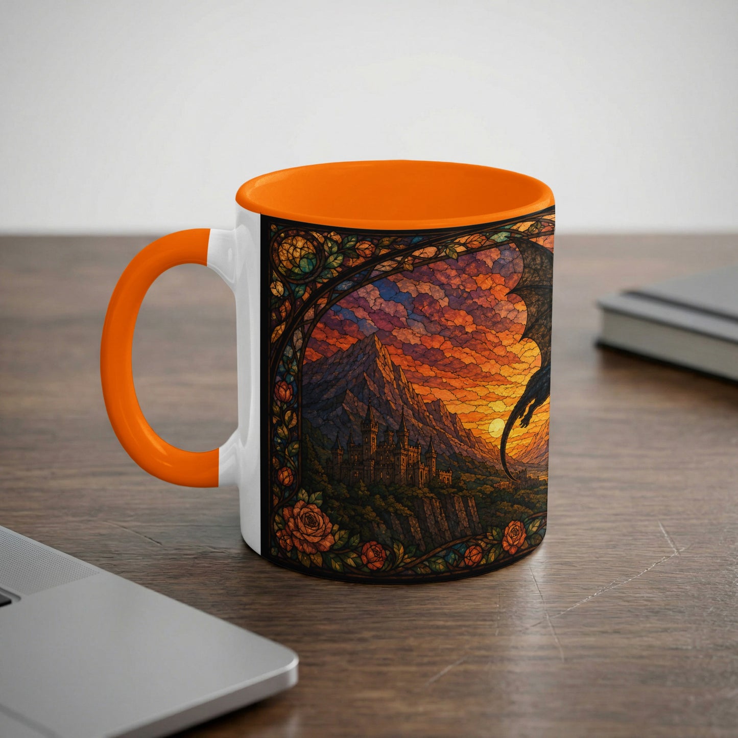 White mug with orange handle displaying stained glass art of a castle and dragon at sunset.