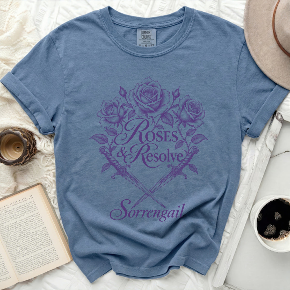 Blue t-shirt with purple roses, swords, and text "Roses & Resolve Sorrengail".