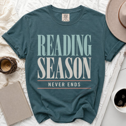 Teal t-shirt with "Reading Season Never Ends" text in cream and light blue.