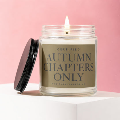Lit glass jar candle with black lid beside it, labeled "Certified Autumn Chapters Only".