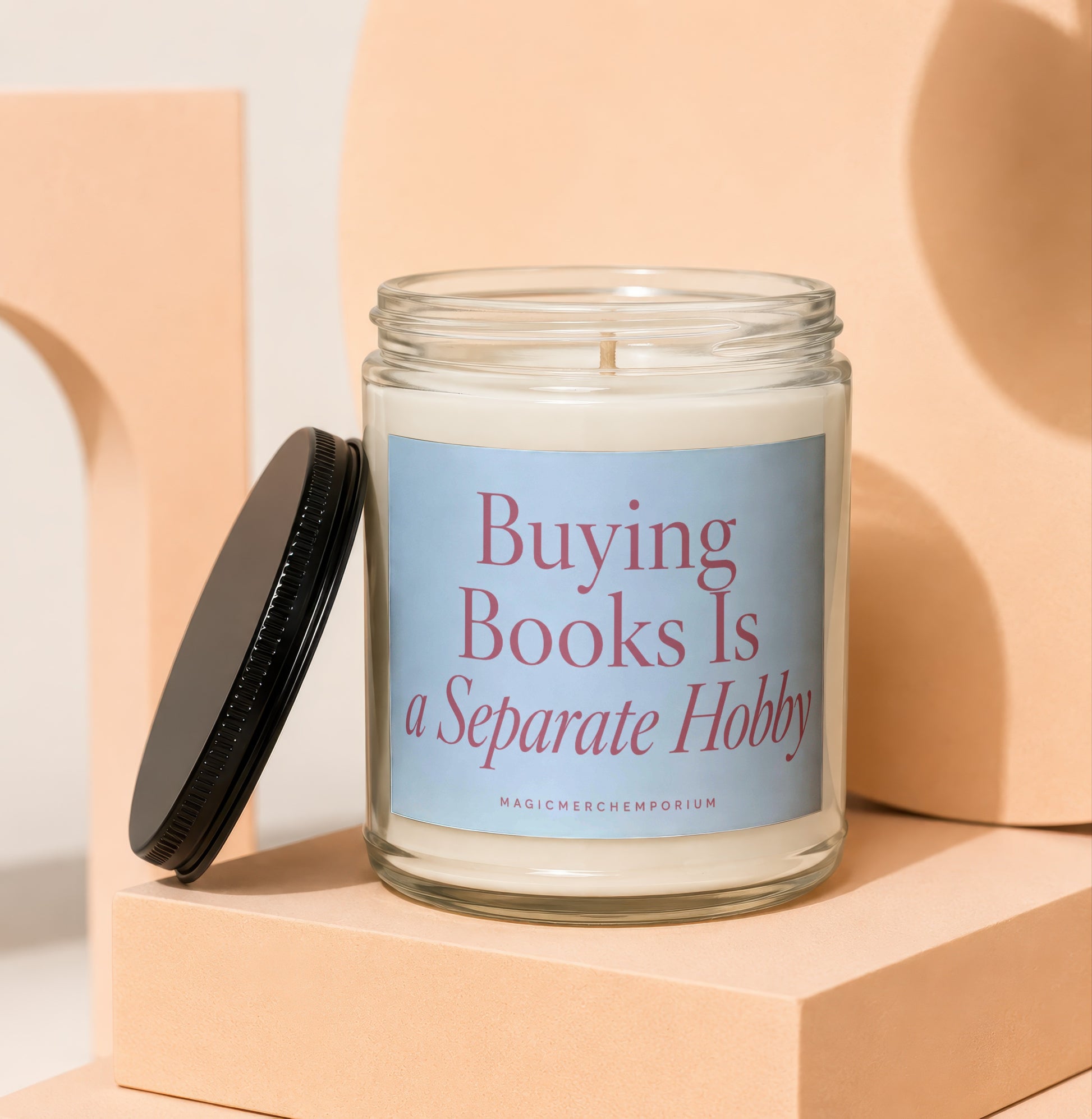 Glass jar candle with "Buying Books Is a Separate Hobby" text.