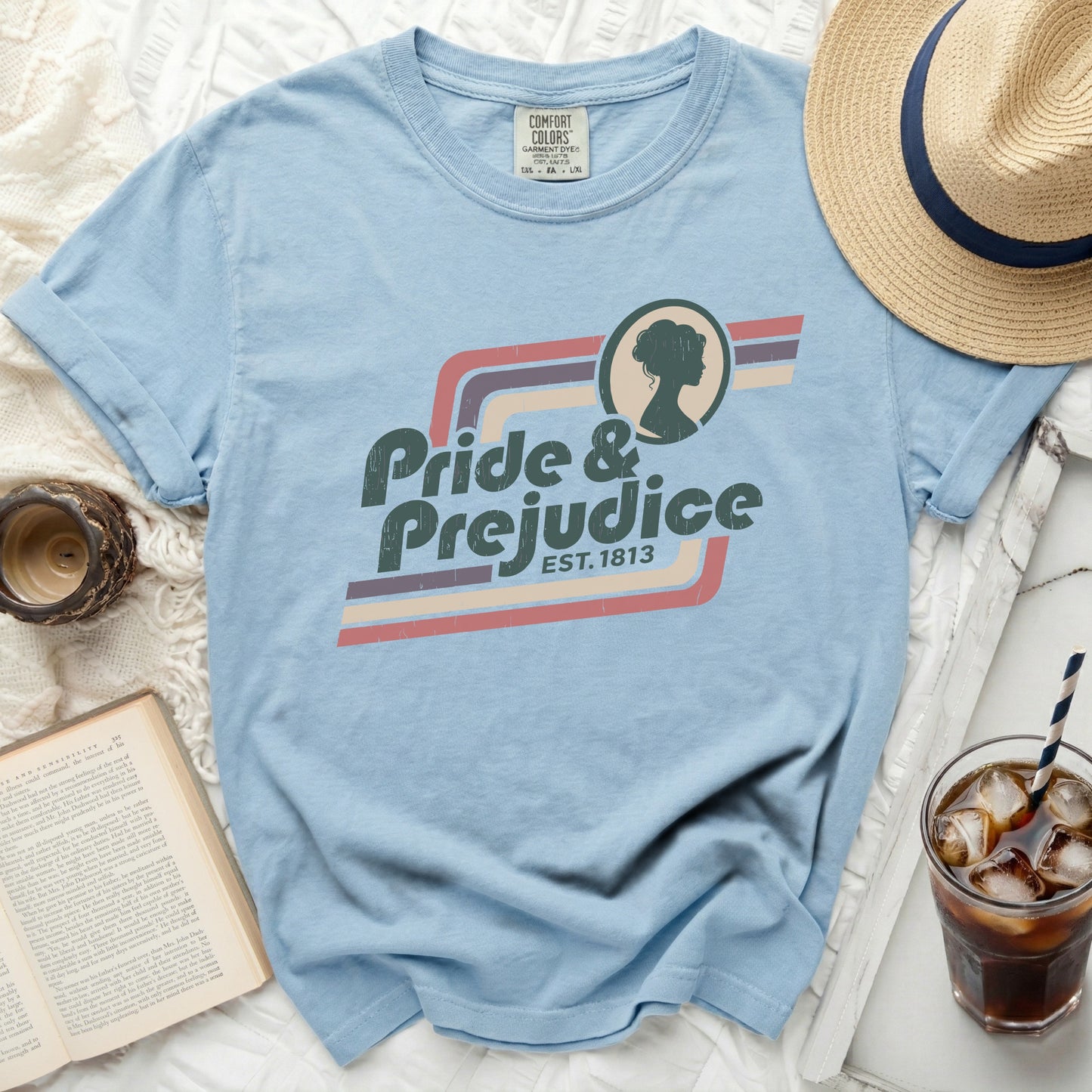 Light blue t-shirt with "Pride & Prejudice Est. 1813" graphic