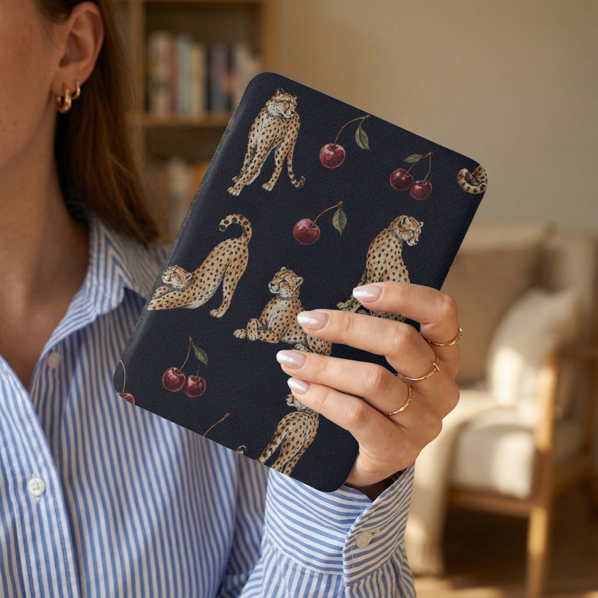 Dark blue cover with cheetahs and cherries pattern, held by a woman.