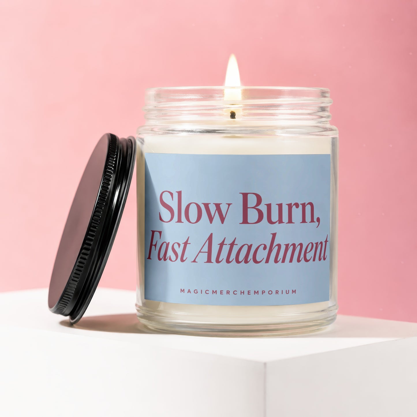 Burning candle in glass jar with "Slow Burn, Fast Attachment" text.