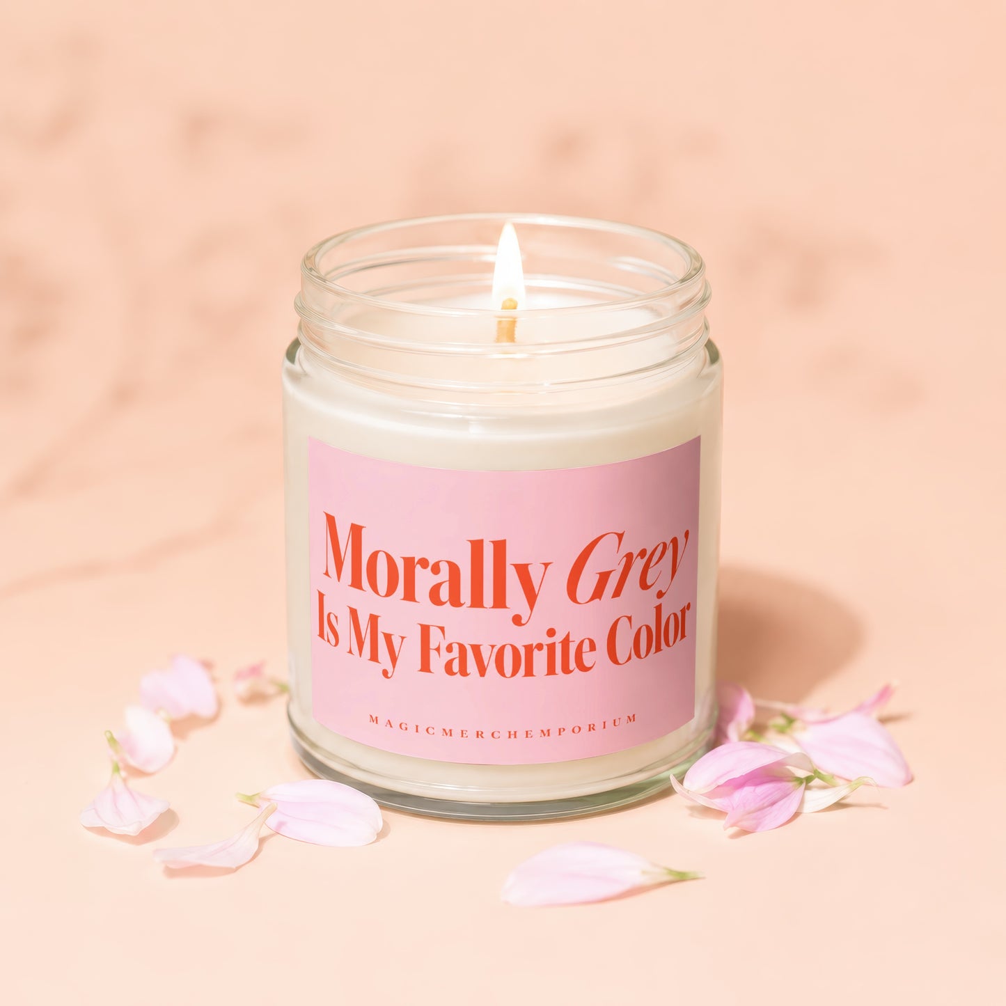Lit candle in glass jar with pink label reading "Morally Grey Is My Favorite Color".
