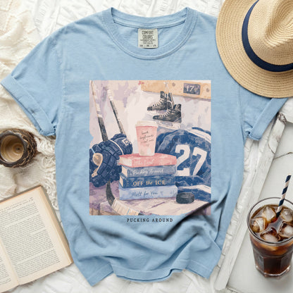 Blue t-shirt with hockey gear, books, and "Pucking Around" text.