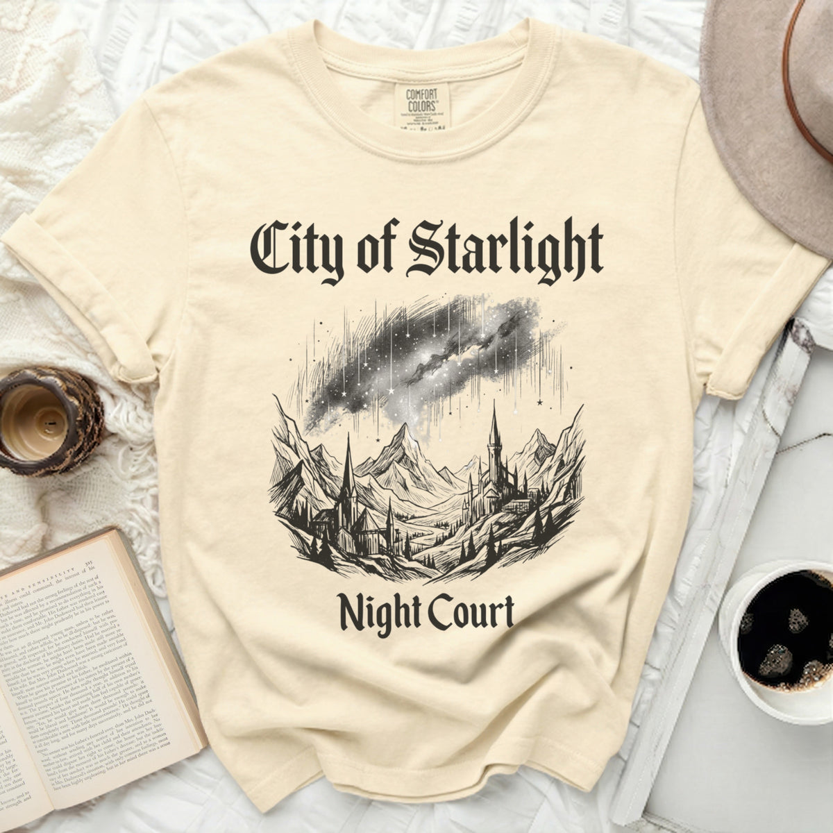 Cream t-shirt with "City of Starlight Night Court" and celestial landscape graphic.