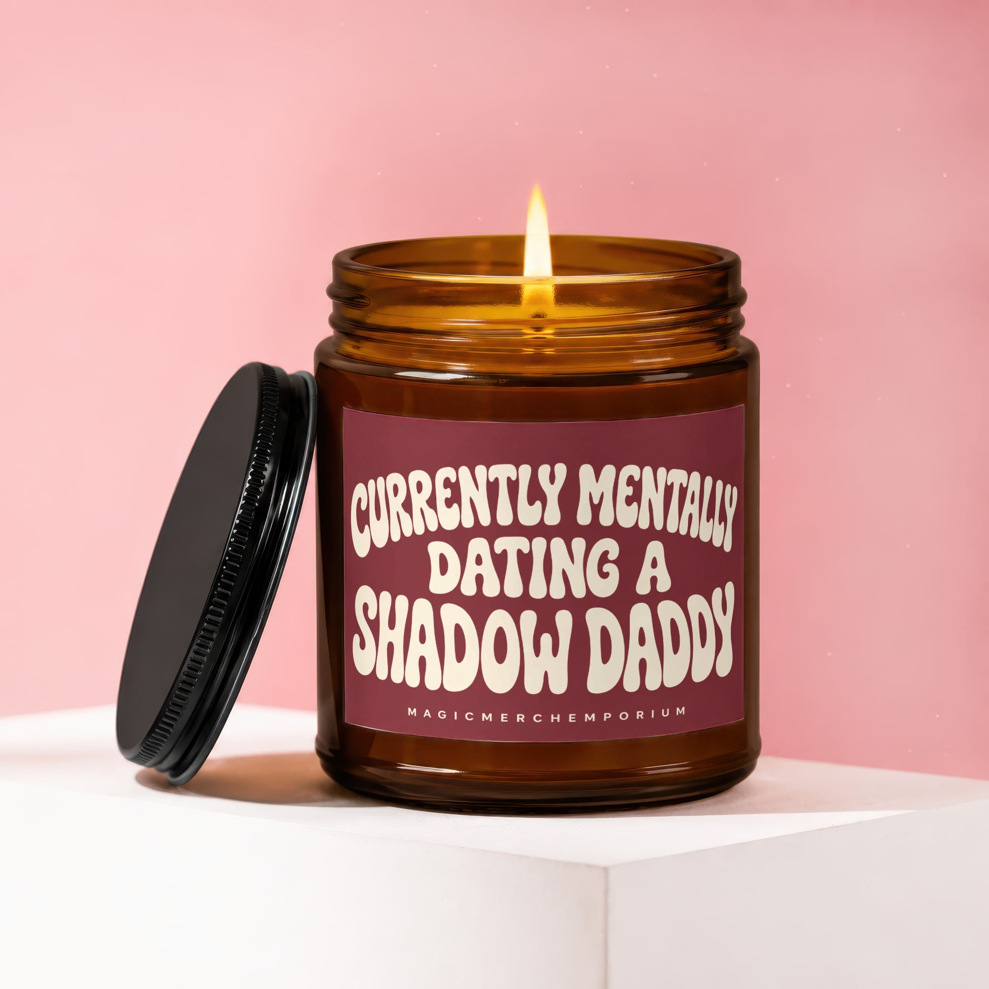 Amber glass candle with lit flame and black lid. Text: "Currently Mentally Dating A Shadow Daddy".