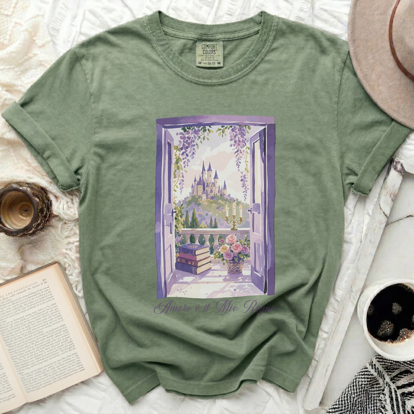 Green t-shirt with illustration of a castle viewed through an open window, with books and flowers.