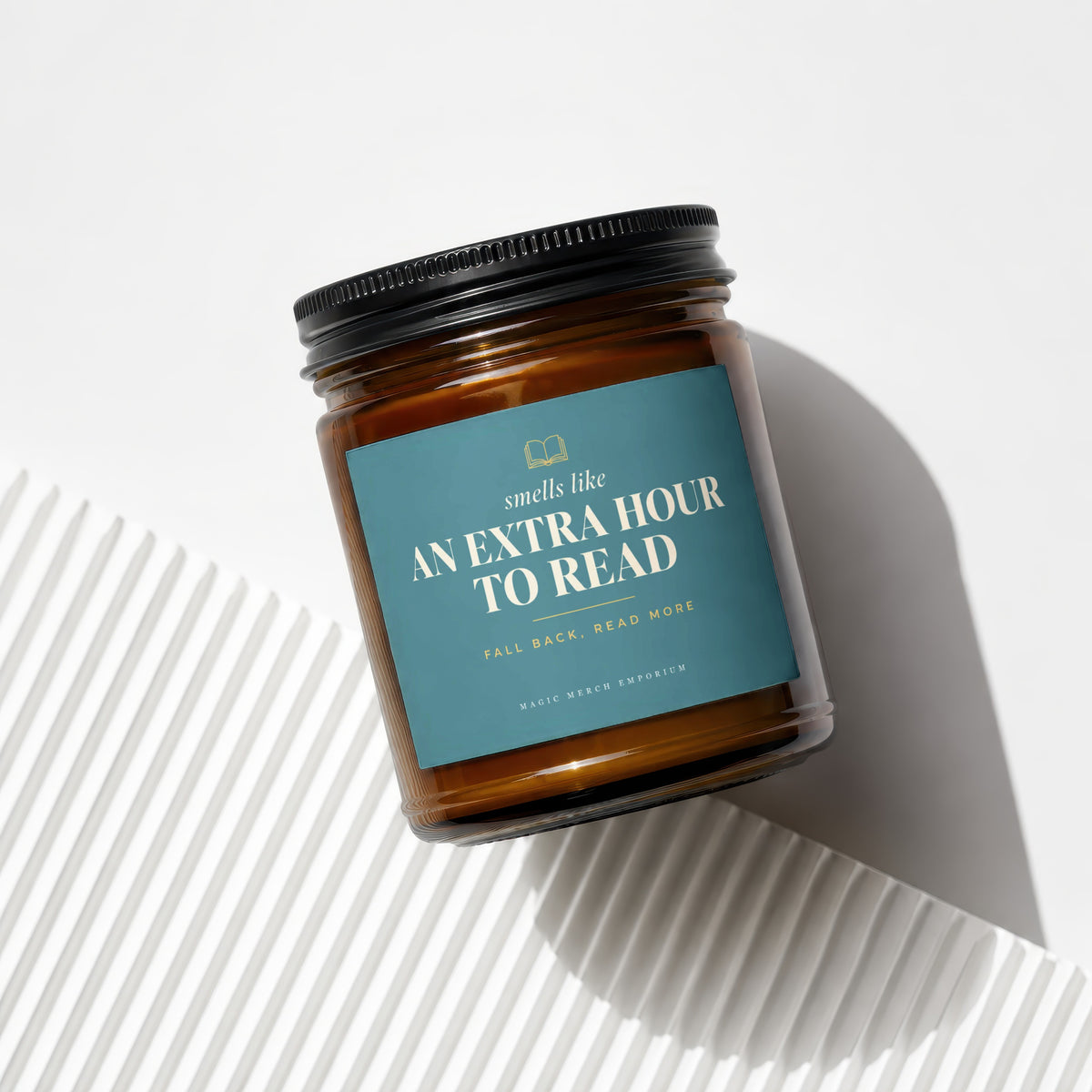 Amber candle in glass jar with black lid, labeled "Smells like an extra hour to read".