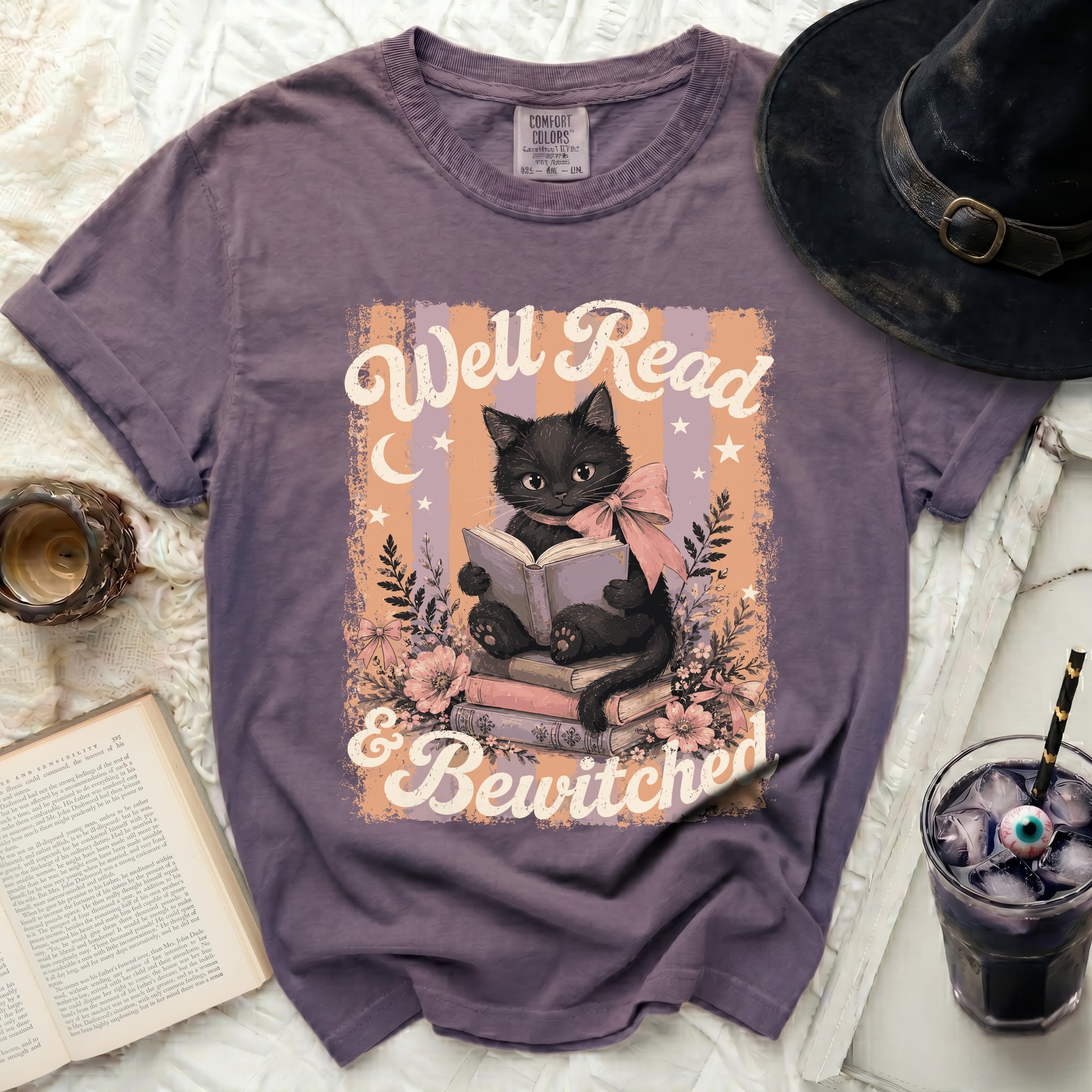 Black cat reading book with "Well Read & Bewitched" text.