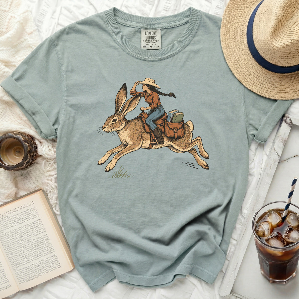 Girl riding a rabbit with books in saddlebags, on a comfort colors t-shirt.