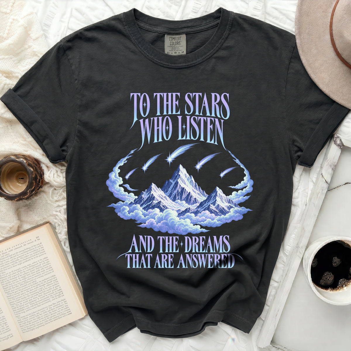 Black t-shirt with "To the stars who listen" and "And the dreams that are answered" text and mountains.