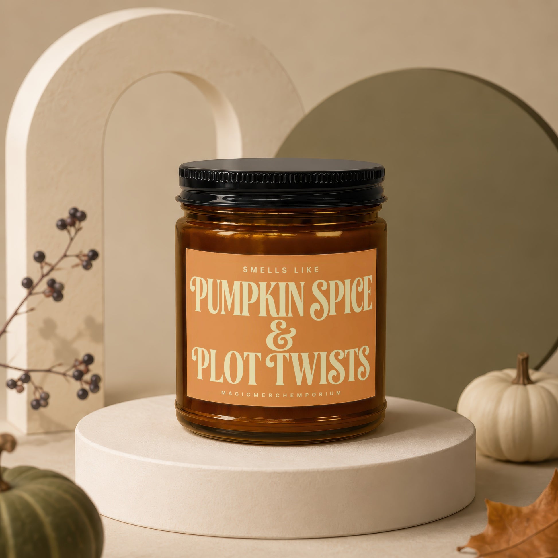 Amber jar candle with black lid, text reads "Smells Like Pumpkin Spice & Plot Twists."