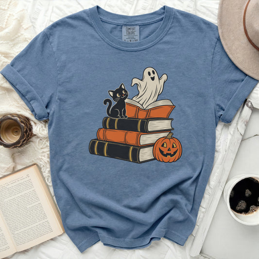 Blue t-shirt with illustration of ghost, black cat, books, and pumpkin.