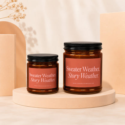 Two amber glass candles with black lids, one larger than the other.