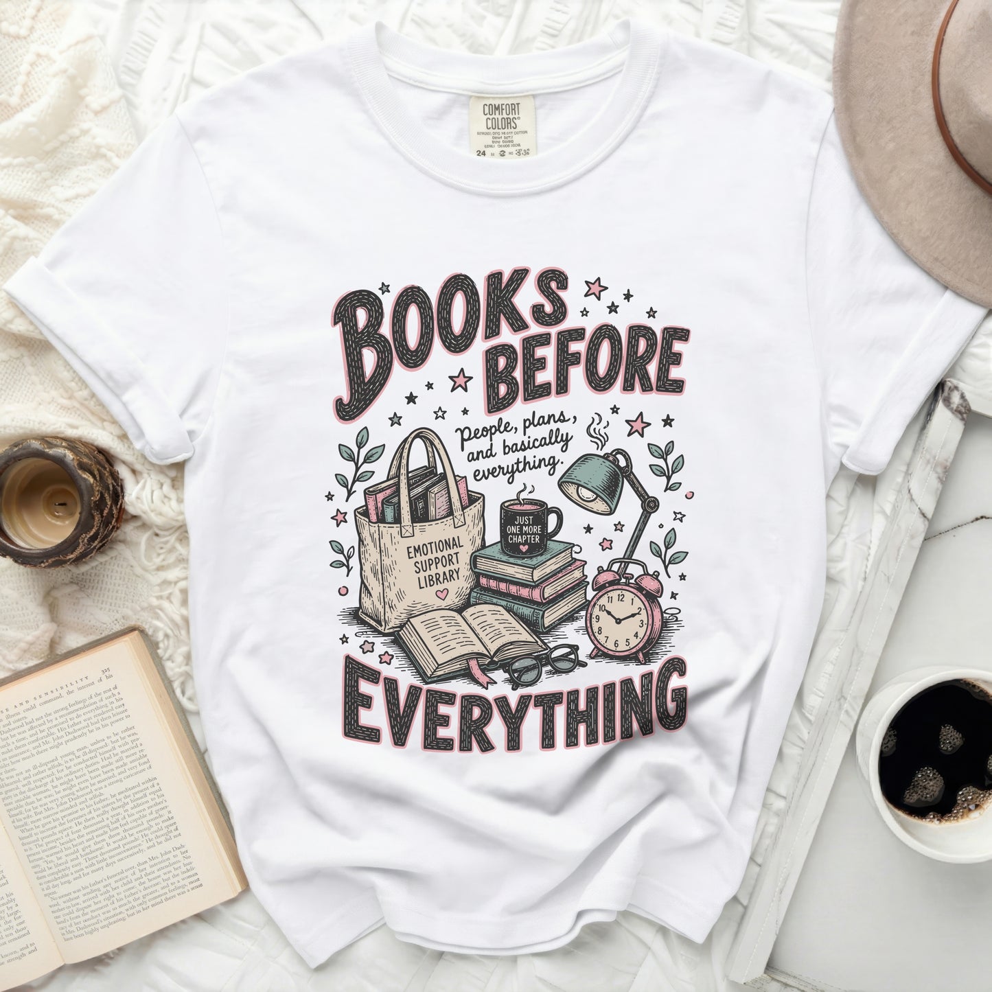 White t-shirt graphic with "Books Before Everything" text and book-themed illustrations.