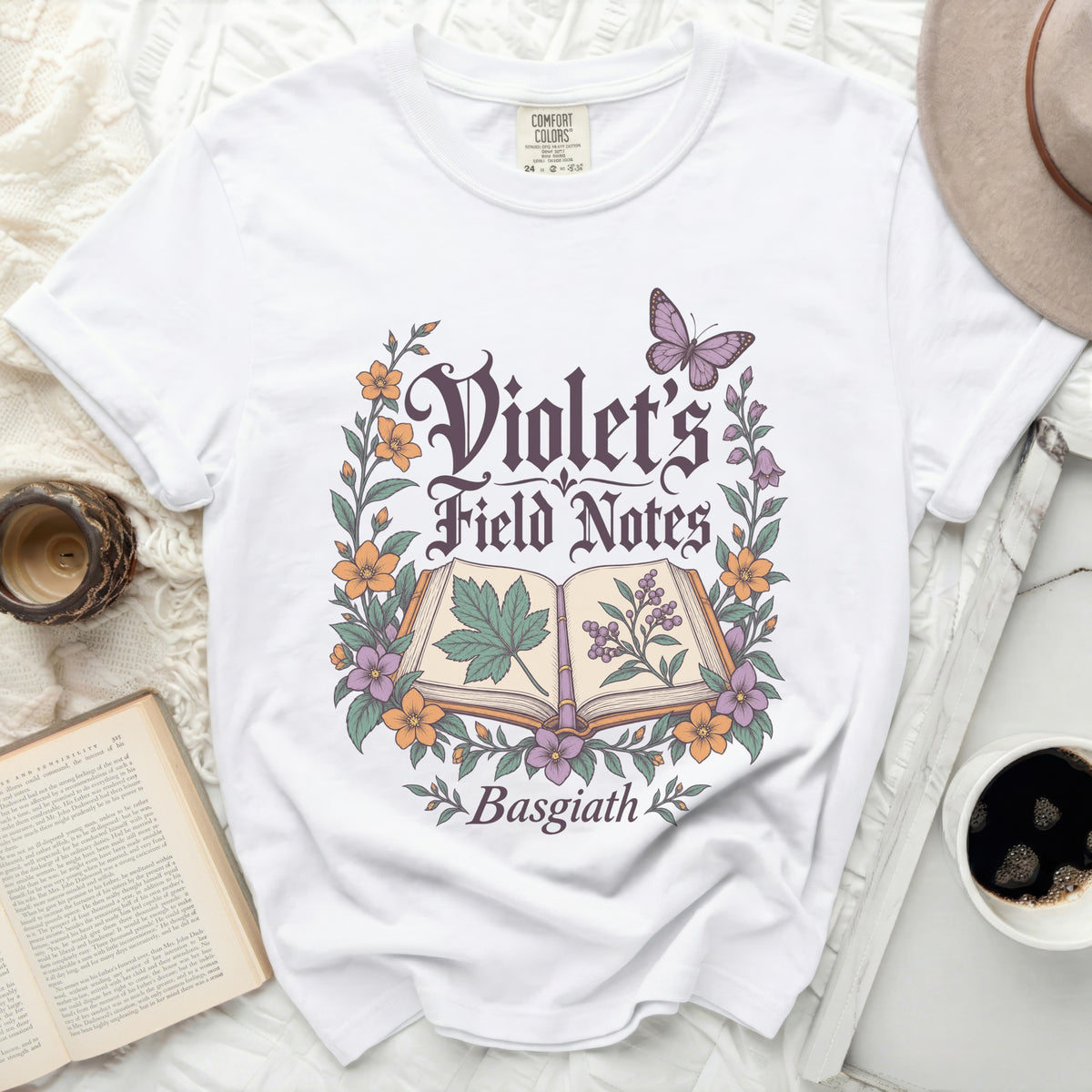 White t-shirt with "Violet's Field Notes Basgiath" and floral design.