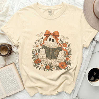 Ghost reading a book surrounded by flowers and bats, with a large orange bow.
