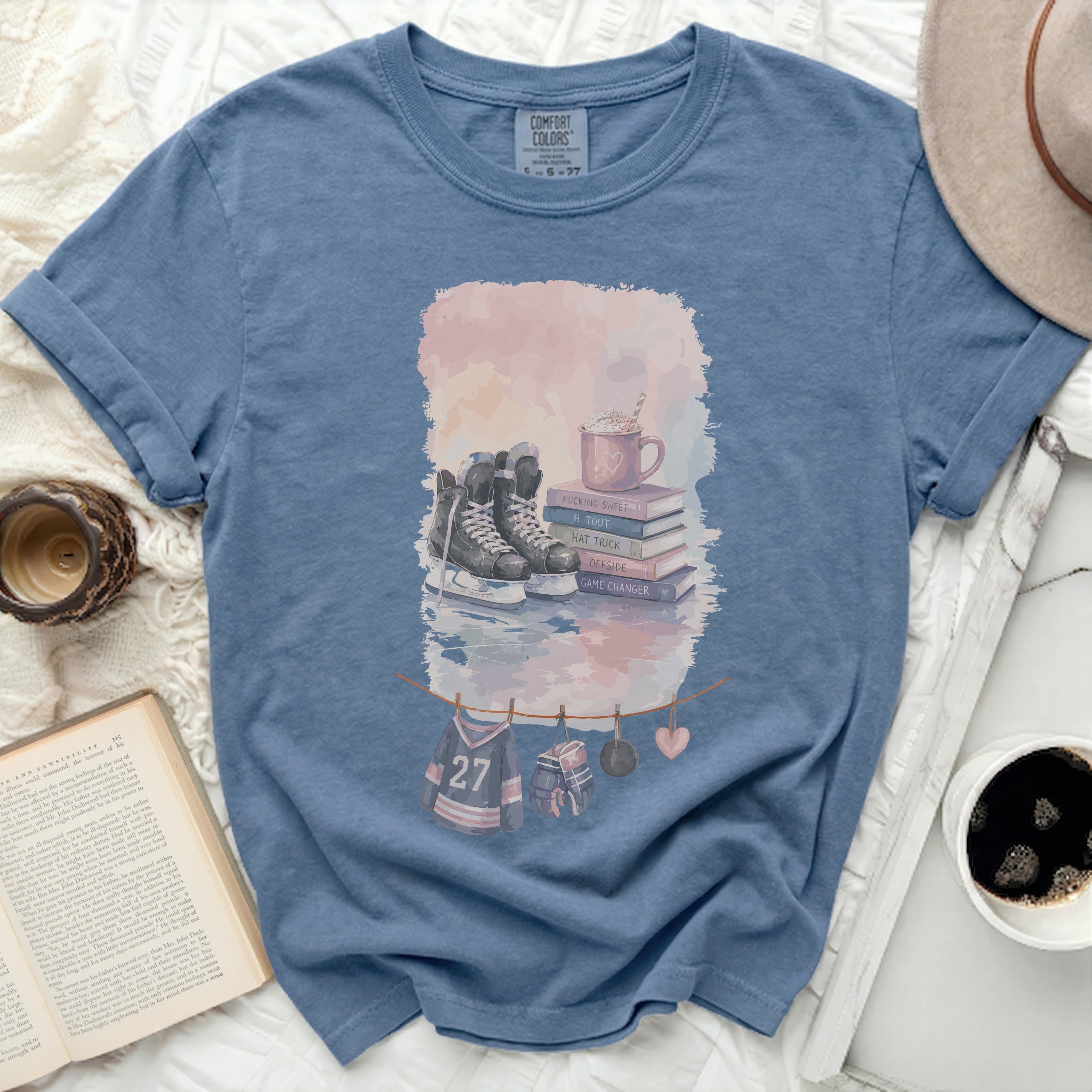 Blue t-shirt with ice skates, mug, and hockey jersey decorations.