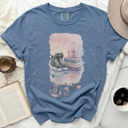 Blue t-shirt with ice skates, mug, and hockey jersey decorations.