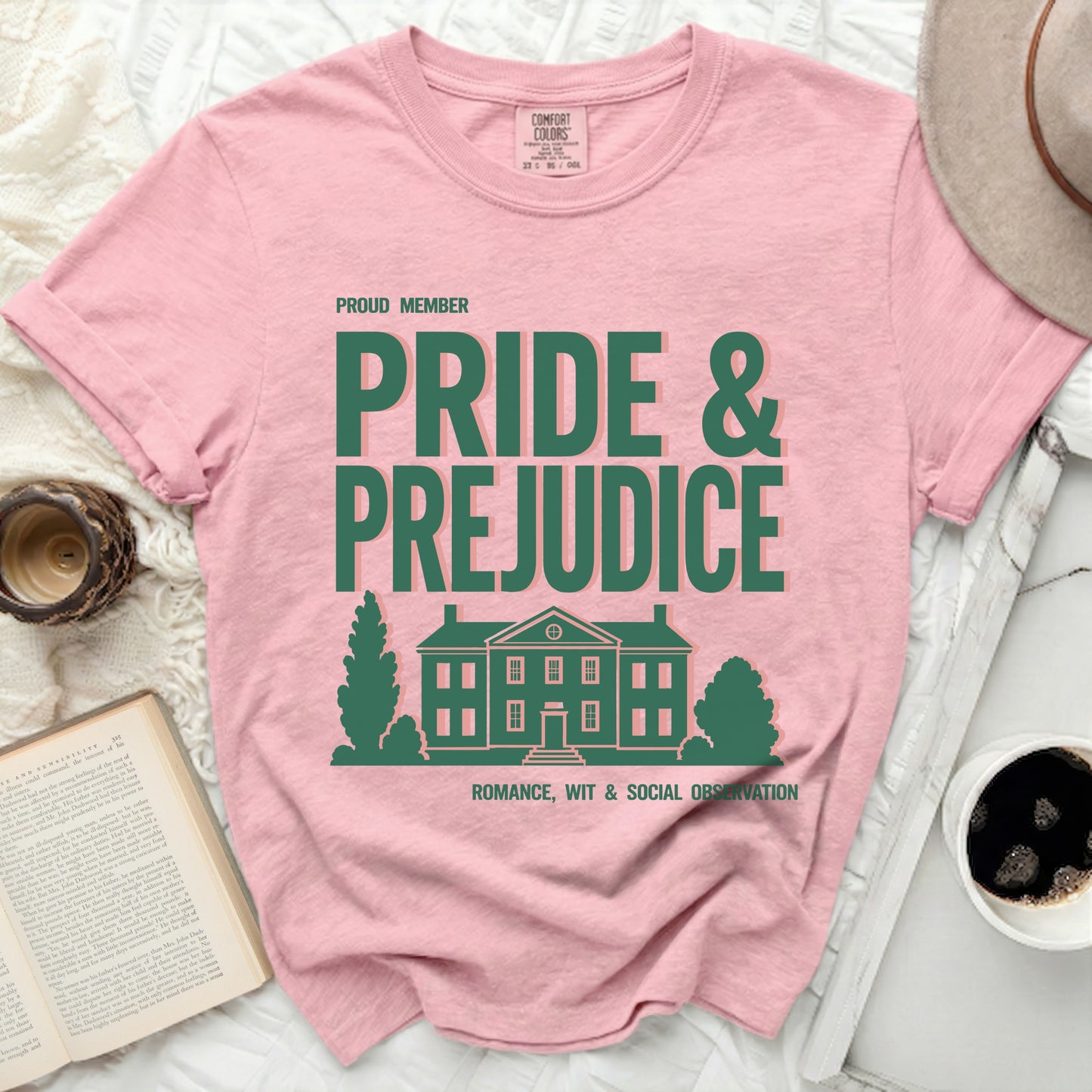 Pink shirt with "Pride & Prejudice" text and house graphic.