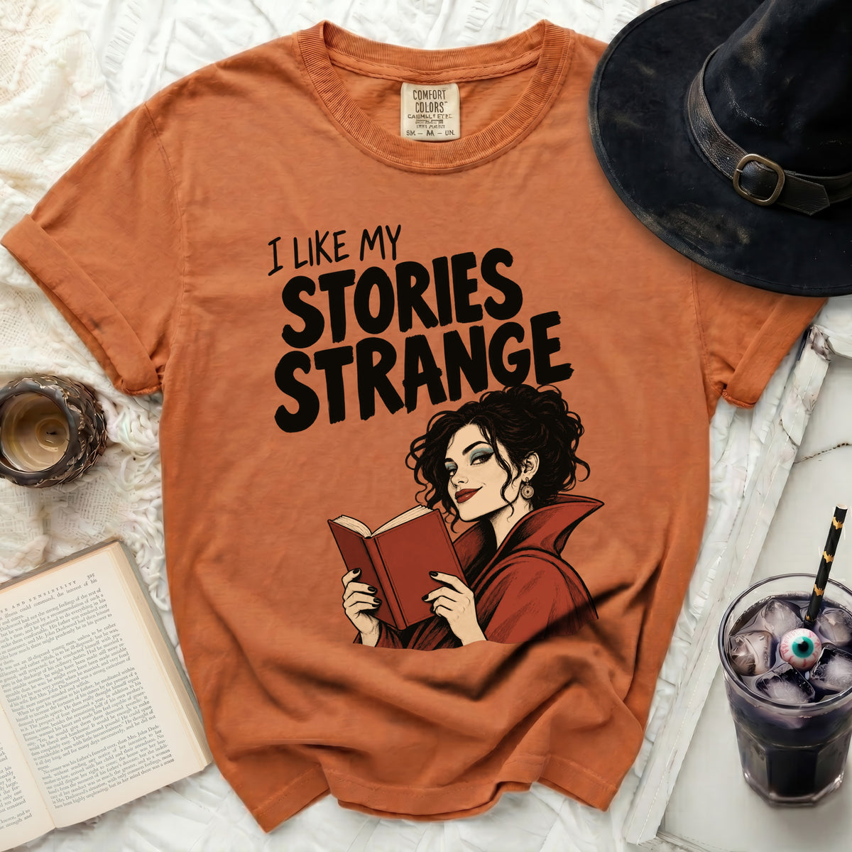 Orange t-shirt with "I LIKE MY STORIES STRANGE" and vampire woman.