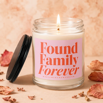 Glass candle with pink label reading "Found Family Forever" and "MagicMerch Emporium"