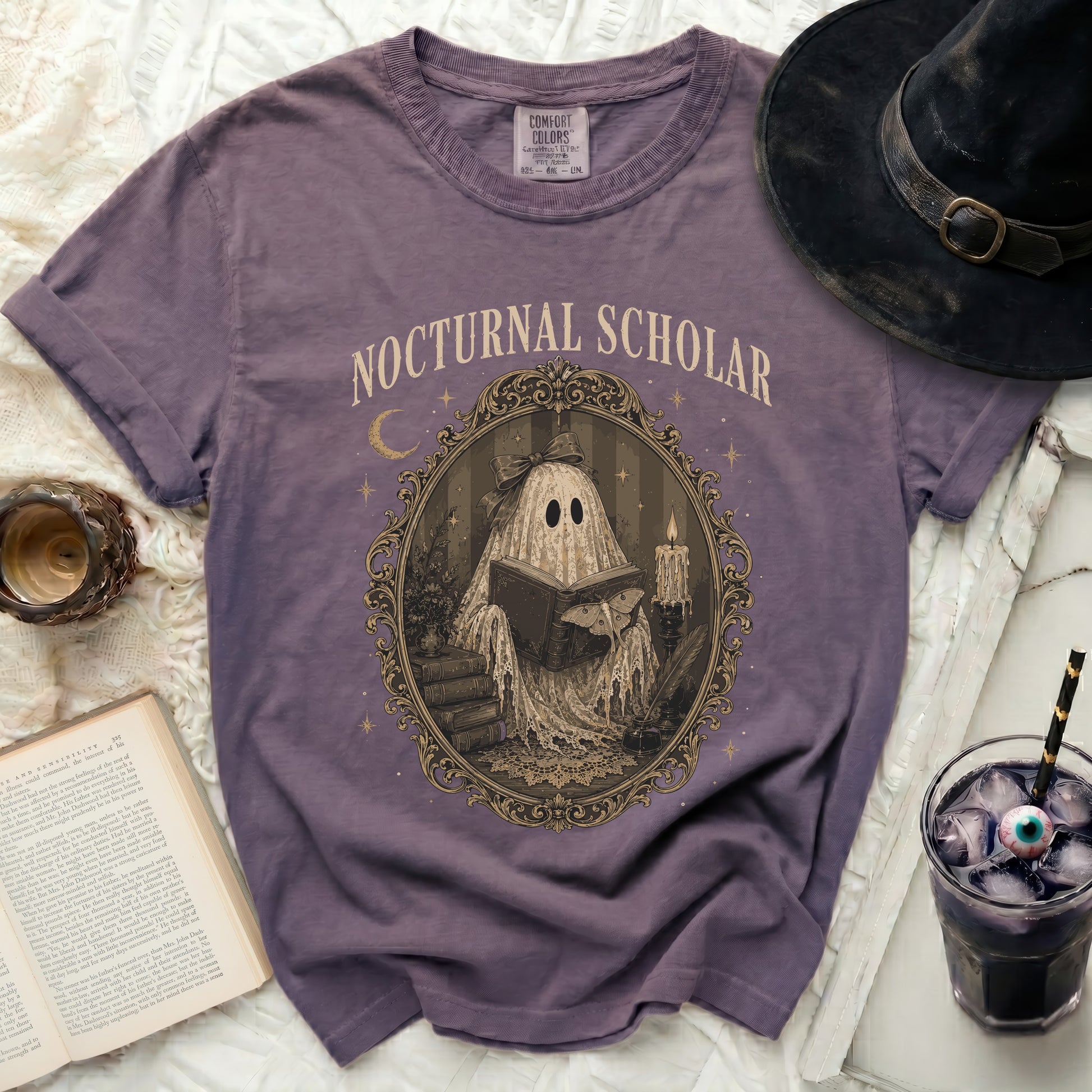 Purple t-shirt with "Nocturnal Scholar" and a ghost reading a book.