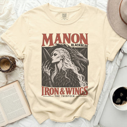Cream t-shirt featuring "MANON BLACKBEAK IRON & WINGS THE THIRTEEN" graphic.