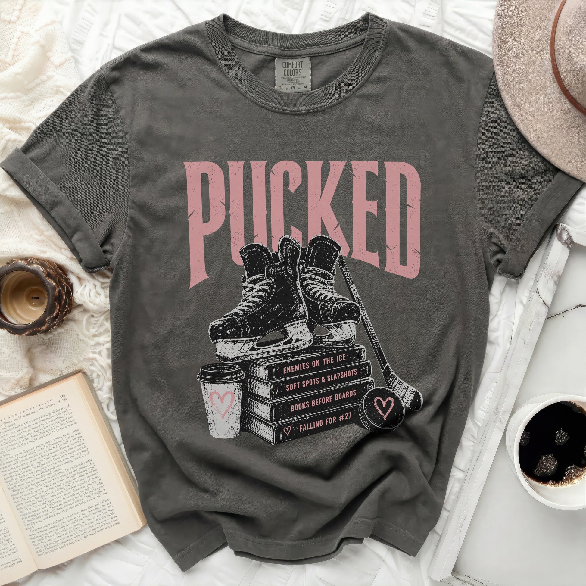 Gray t-shirt with "Puckered" text and hockey skates over books.
