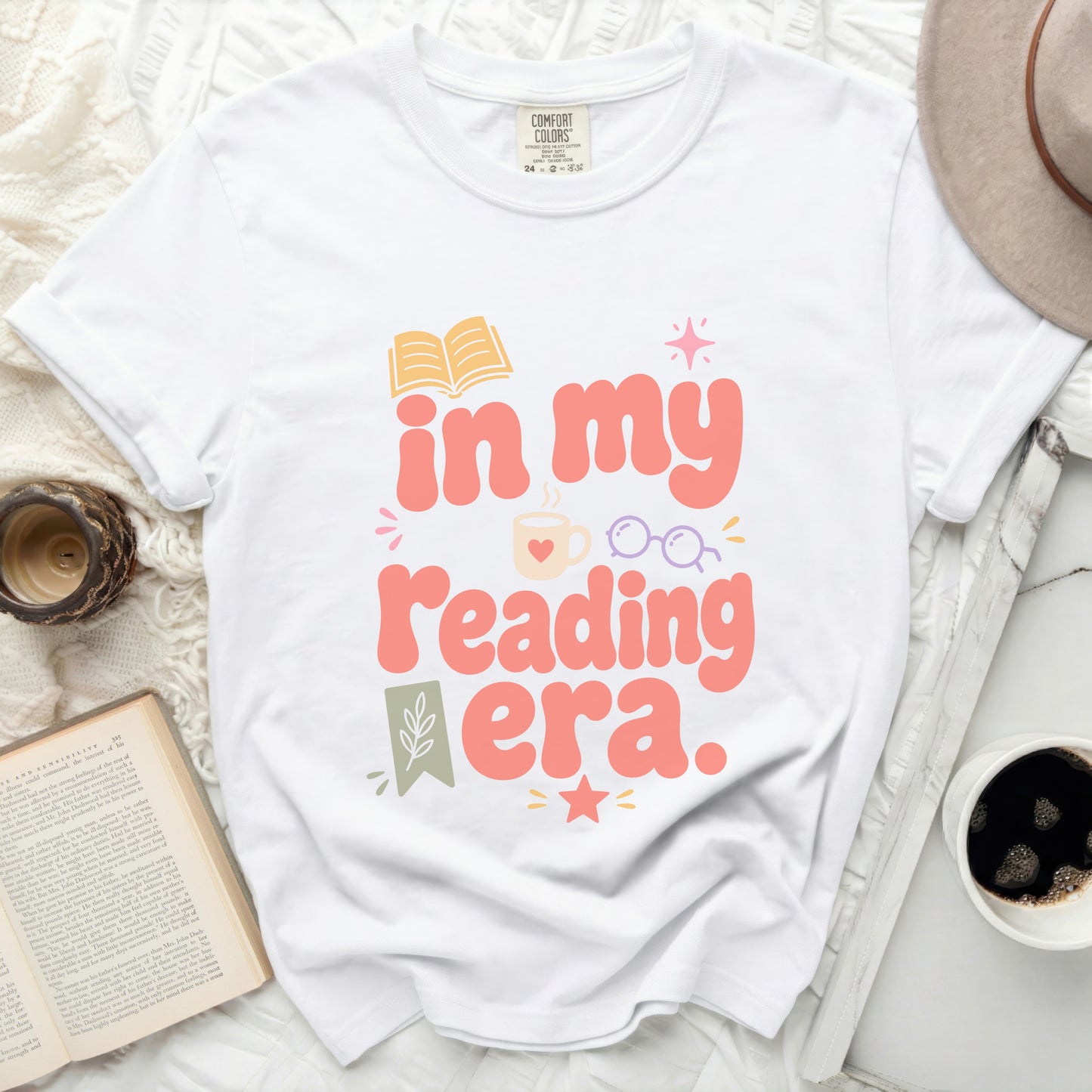 White t-shirt with "in my reading era." text and book graphic.