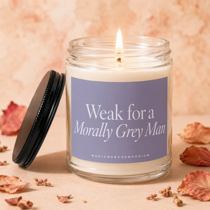 Lit jar candle with purple label reading "Weak for a Morally Grey Man"