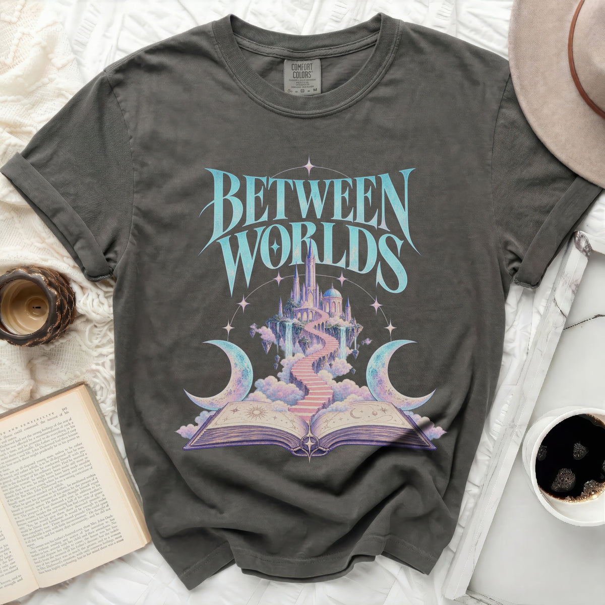 T-shirt with "BETWEEN WORLDS" text and fantasy castle design.