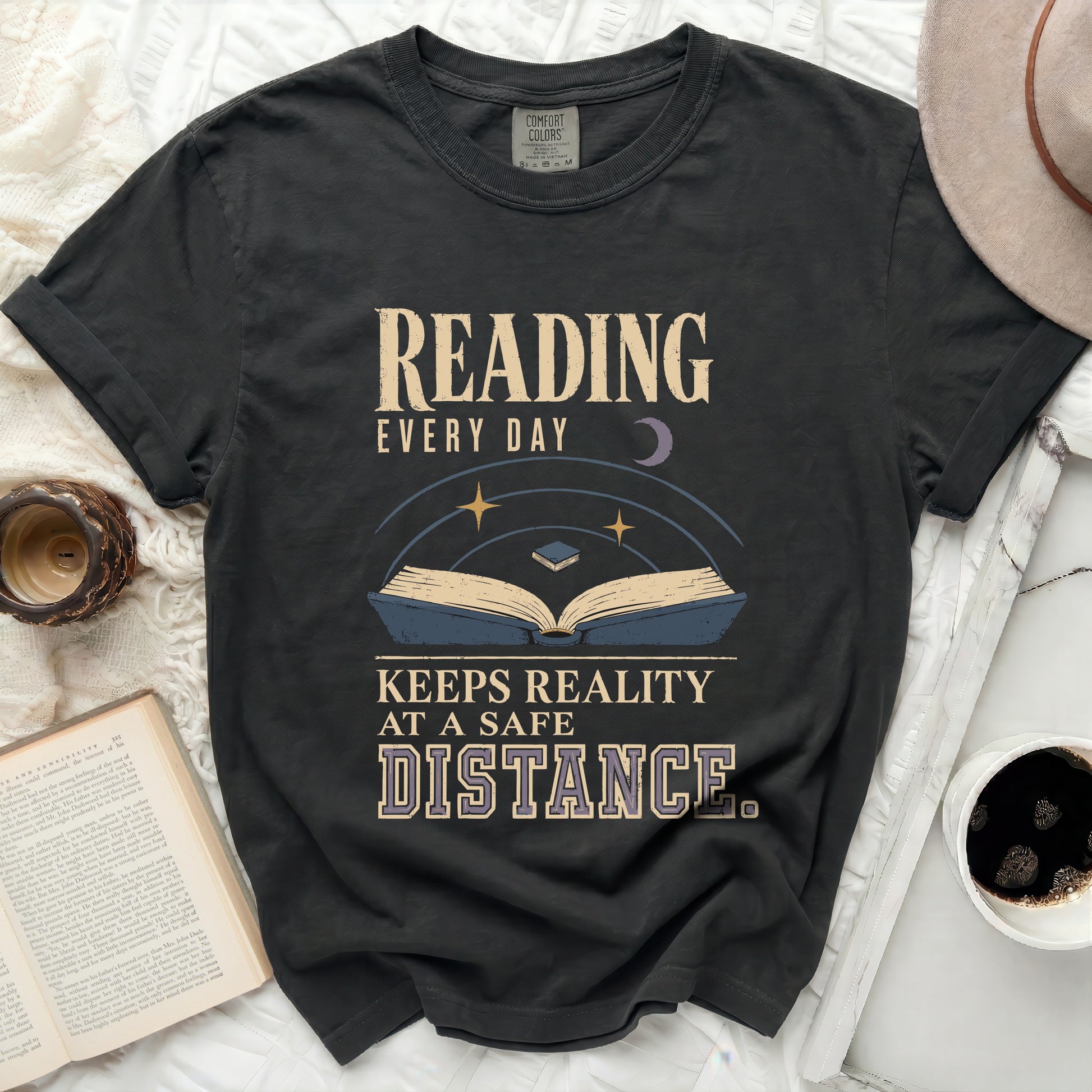 T-shirt with text "READING EVERY DAY KEEPS REALITY AT A SAFE DISTANCE".