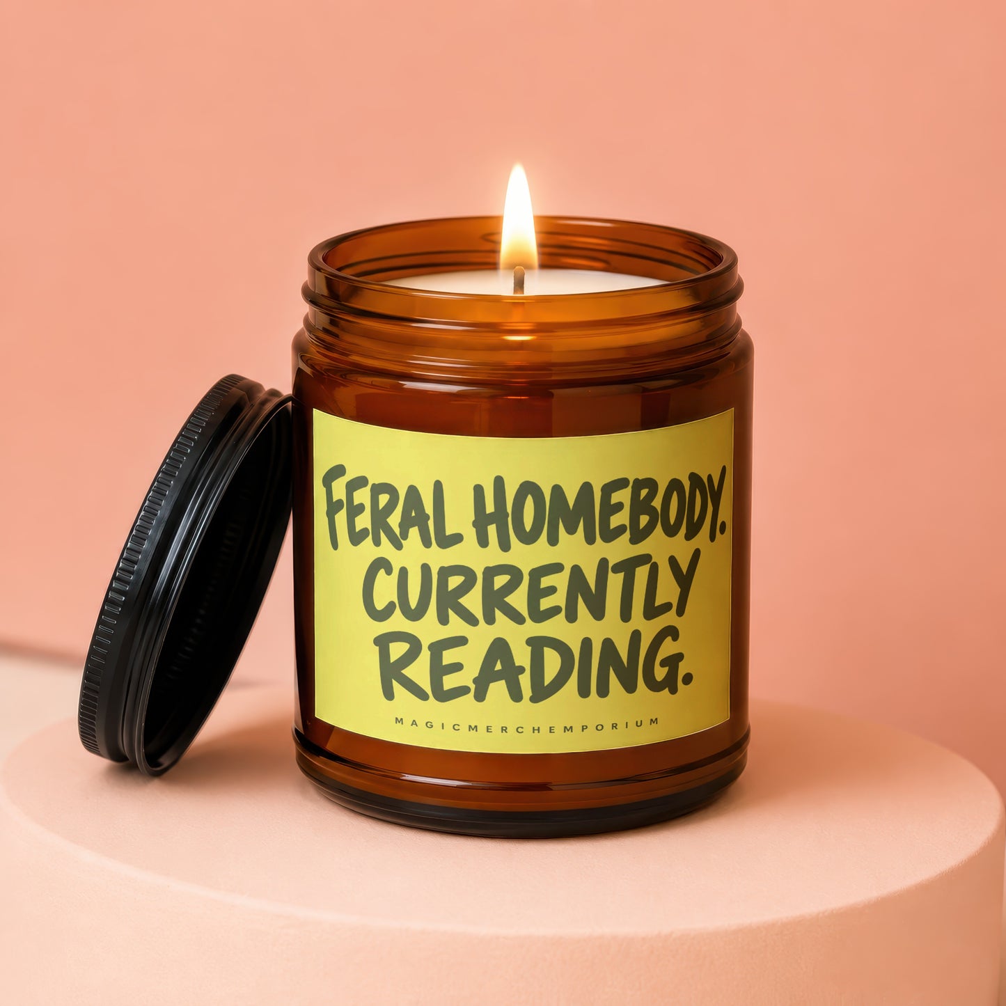Brown glass candle with "Feral Homebody Currently Reading" on yellow label.