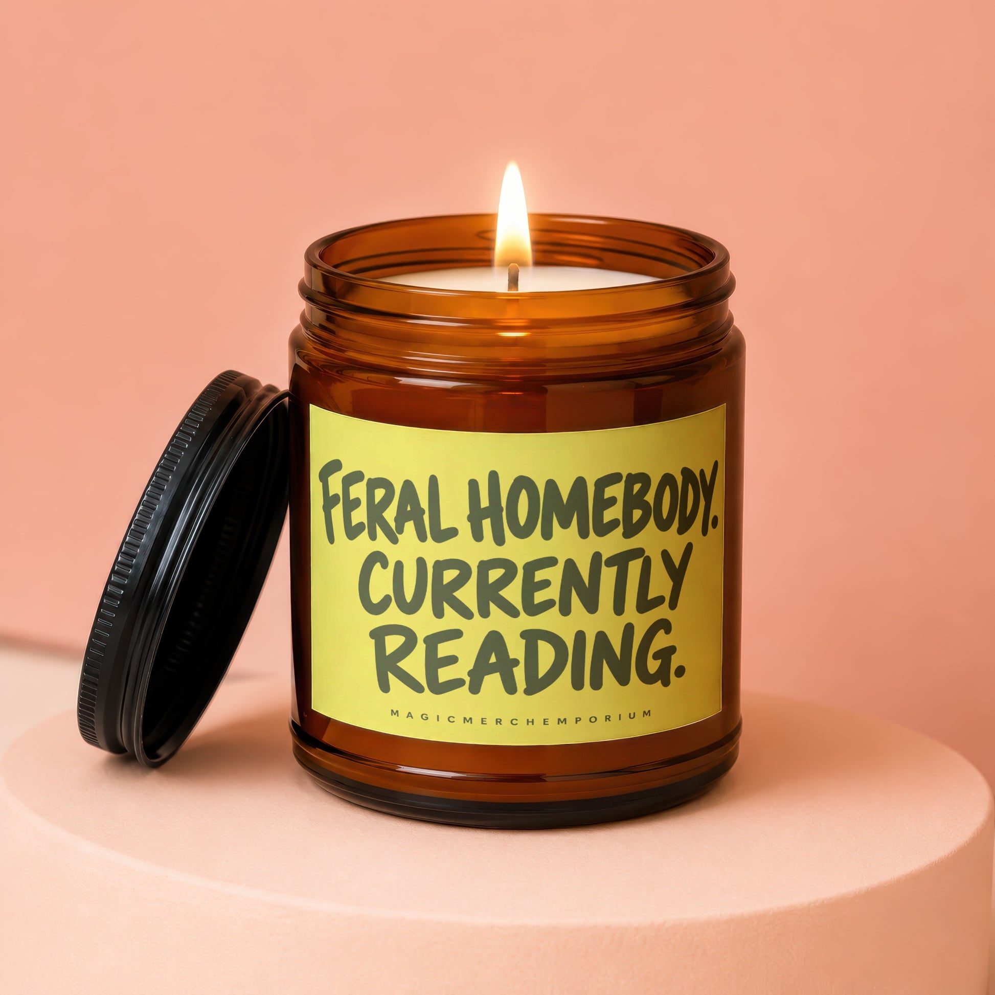 Brown glass candle with "Feral Homebody Currently Reading" on yellow label.