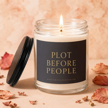Glass candle with lit wick and black label reading "PLOT BEFORE PEOPLE".