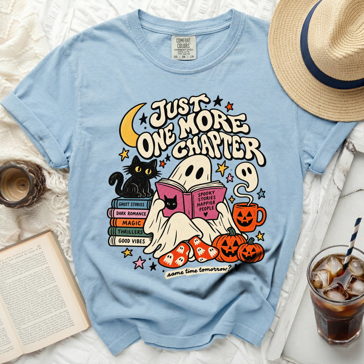Light blue t-shirt with ghost, cat, books, pumpkins, and "Just One More Chapter" text.