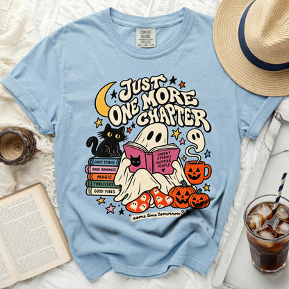 Light blue t-shirt with ghost, cat, books, pumpkins, and "Just One More Chapter" text.